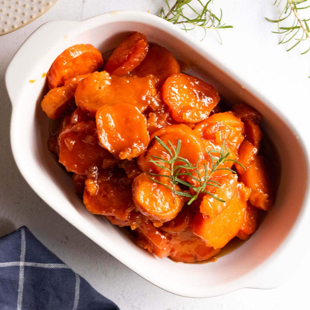 Cooked yams with a sweet glaze in white bowl, ready to serve.