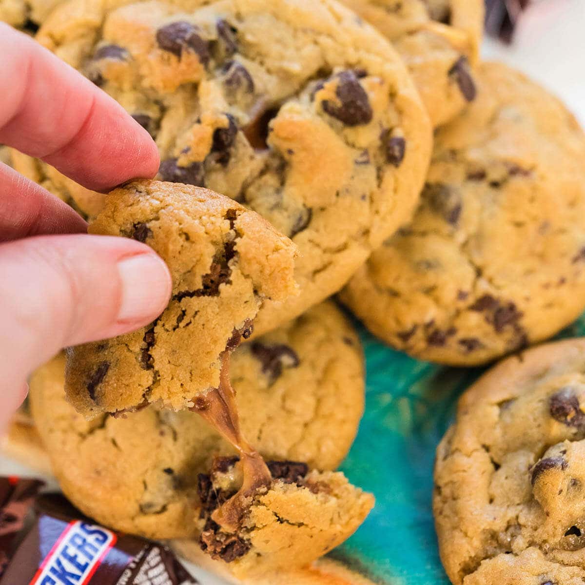 Hand holding cookie showing the melty caramel nougat