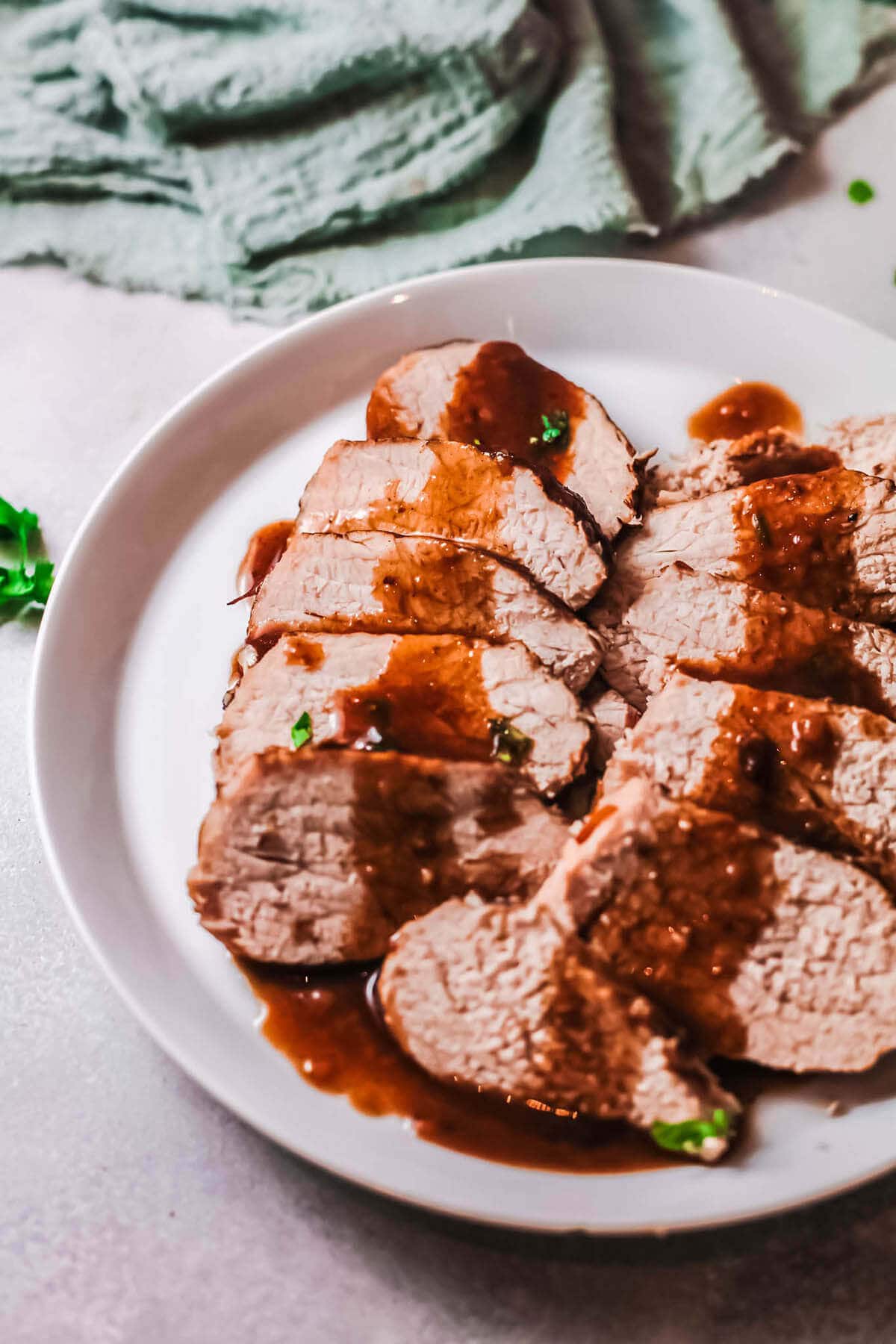 Instant Pot Balsamic Pork Loin sliced on a white platter drizzled with glaze.