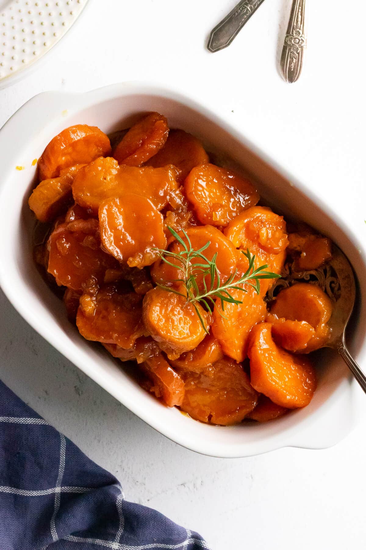 Candied sweet potatoes in a white serving dish.