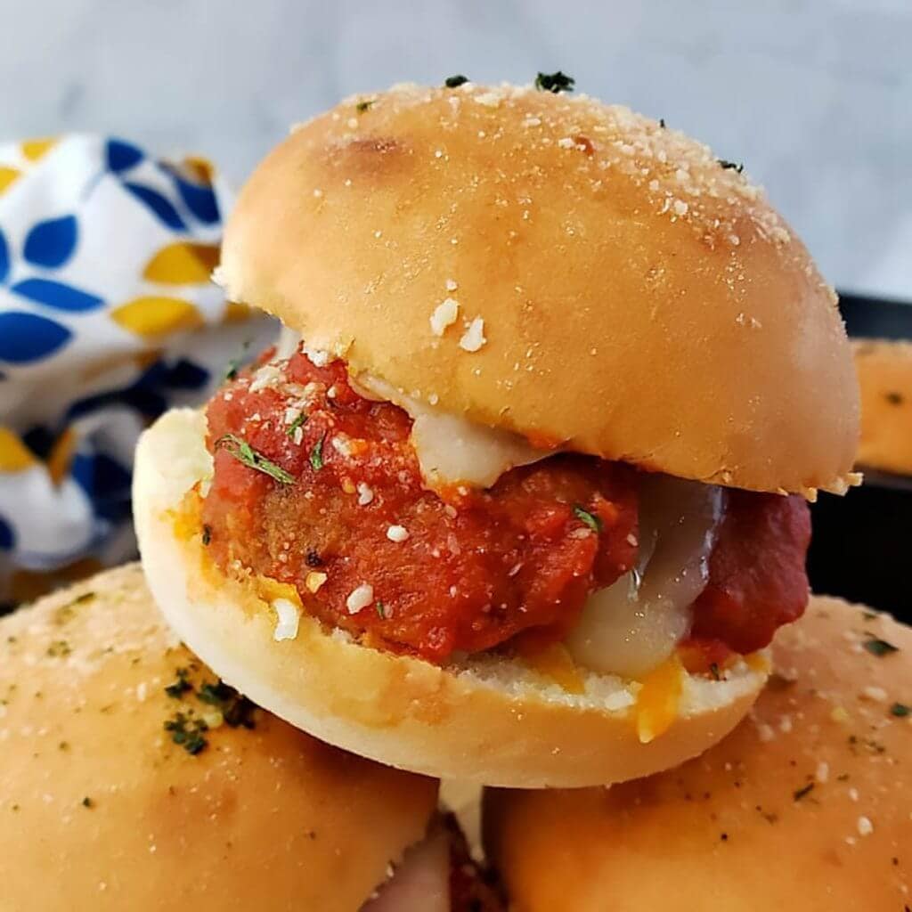 A stack of meatball sliders on a plate.