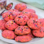 A white platter piled high with strawberry Funfetti cookies