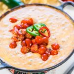 Mexican Velveeta Cheese Dip in cast iron skillet topped with tomatoes.