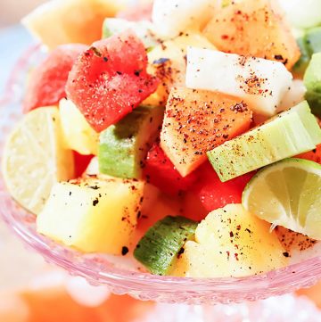 Mexican Fruit Salad topped with Tajin in pink bowl.