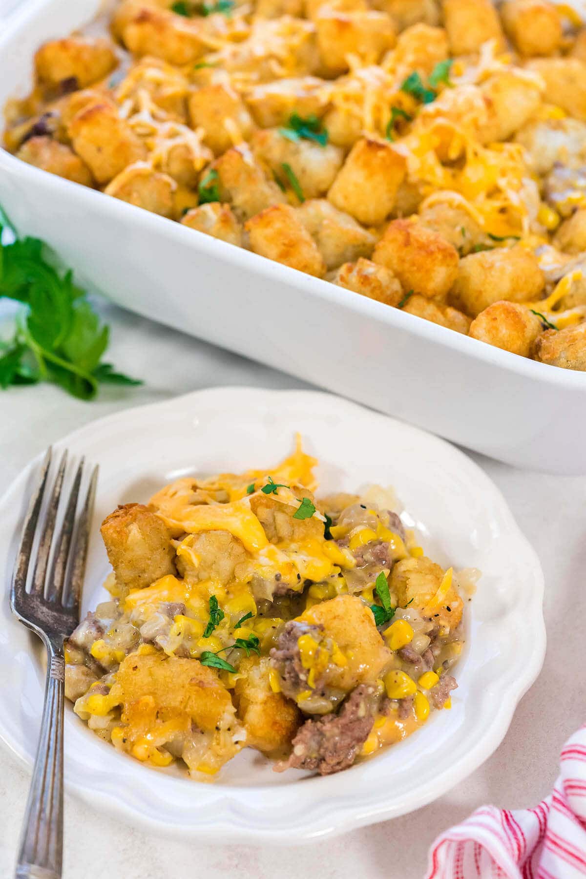 Cowboy Casserole in dish with a serving heaped on a plate with fork.