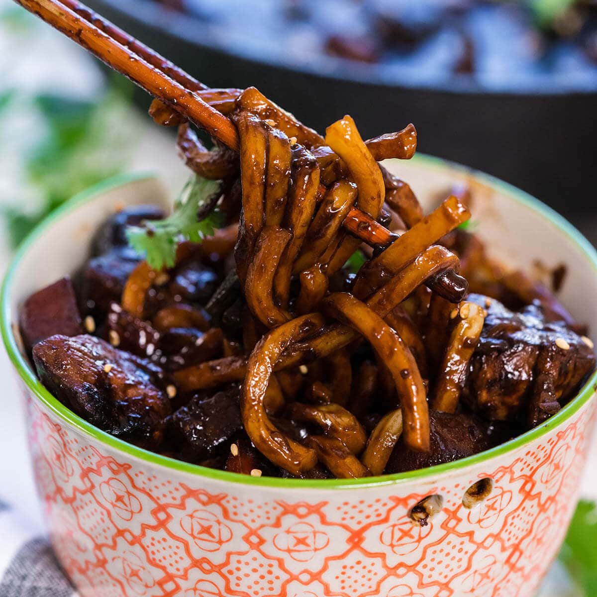 jajangmyeon noodles in a bowl being served with chopsticks.
