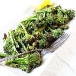 Roasted broccoli on white plater with lemon.