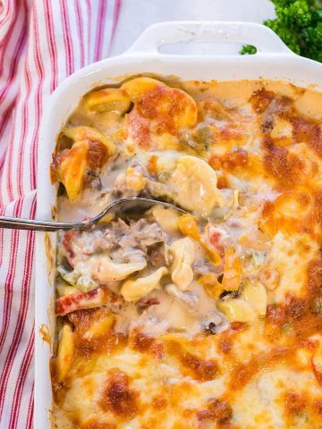 Baked Philly cheesesteak Tortellini Casserole with spoon.