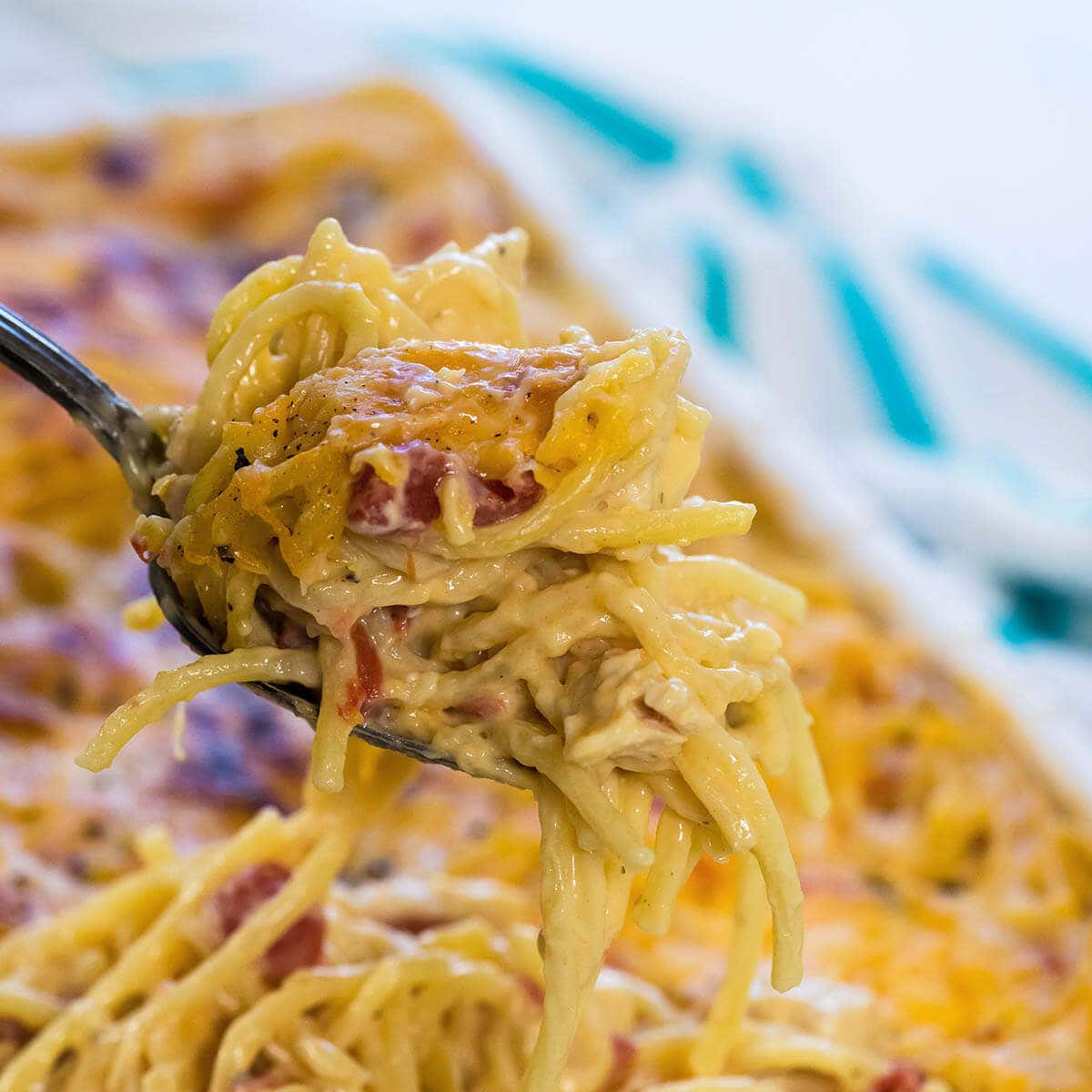 Spoon filled with chicken spaghetti over casserole dish.