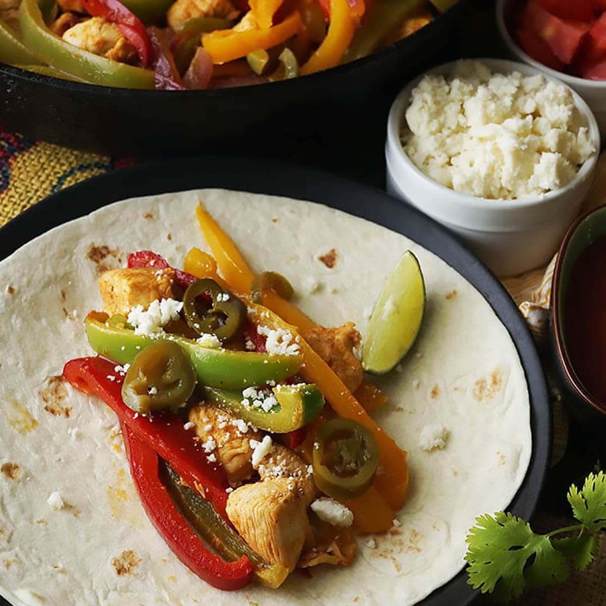 Chicken Fajitas on flour tortilla topped with cheese and lime.