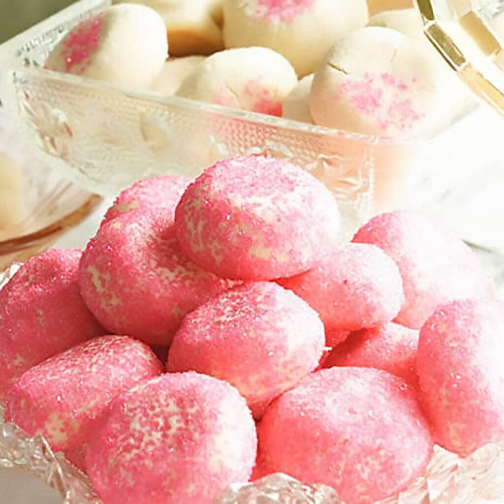 Butter cookies with pink sprinkles in glass bowl.