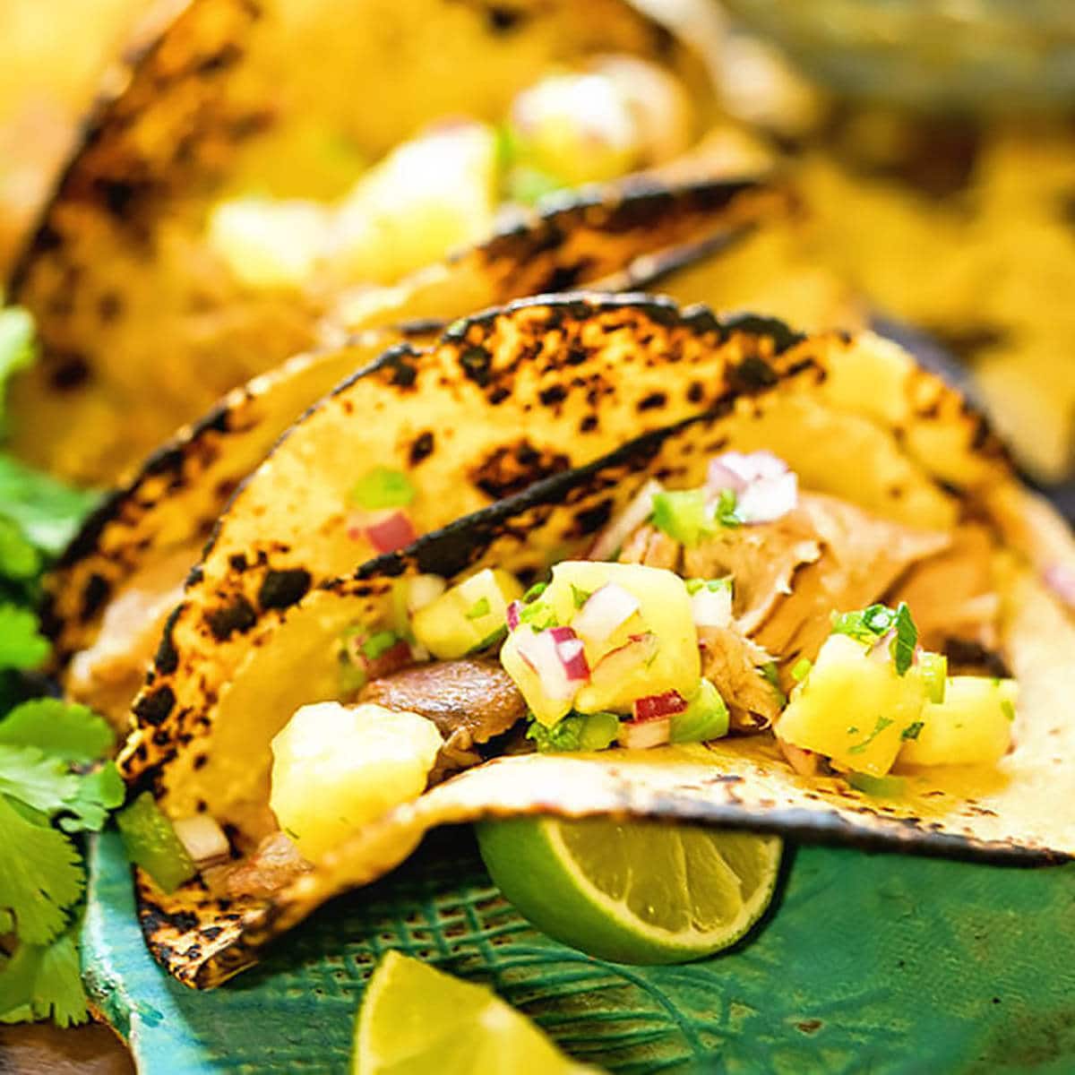 Pork tacos topped with pineapple salsa. 