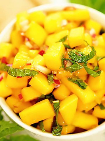 Spicy Mango Salsa in white bowl topped with mint.