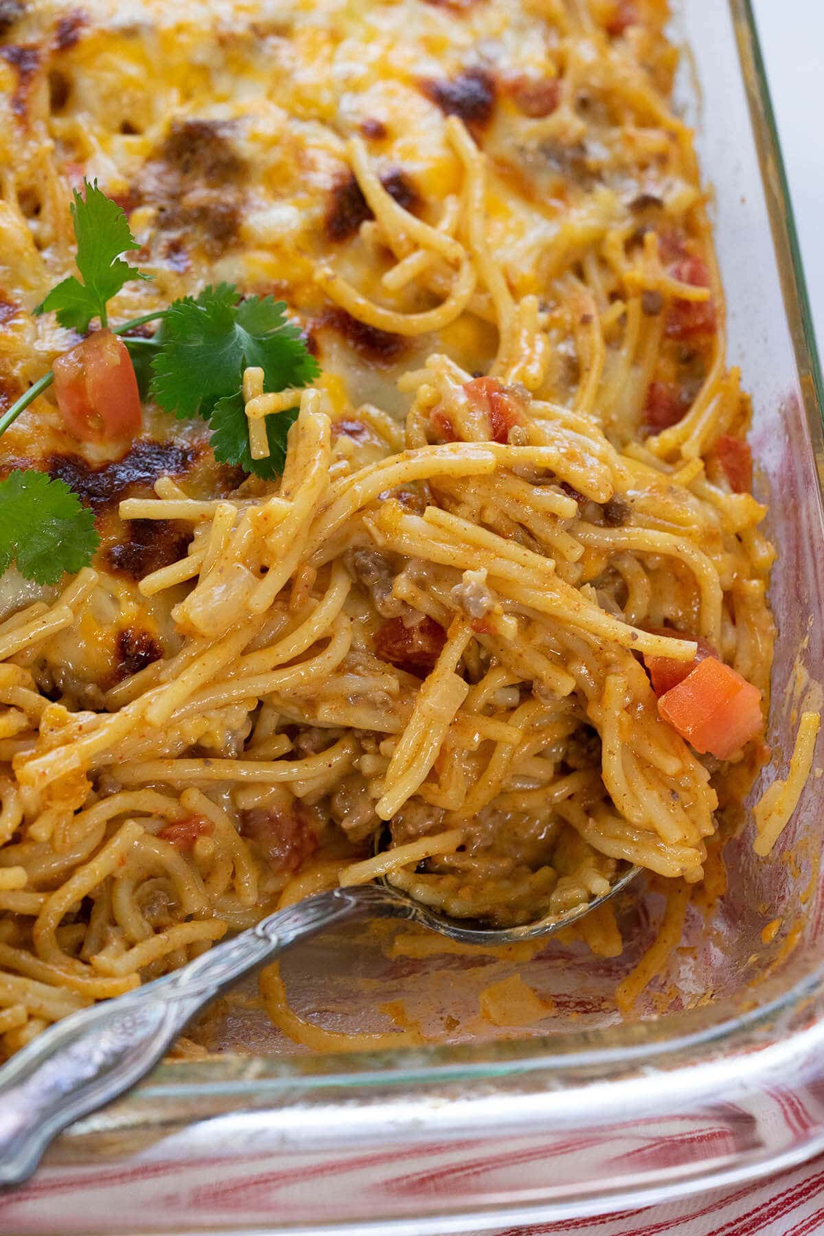 Taco Spaghetti Recipe in casserole dish with serving spoon.