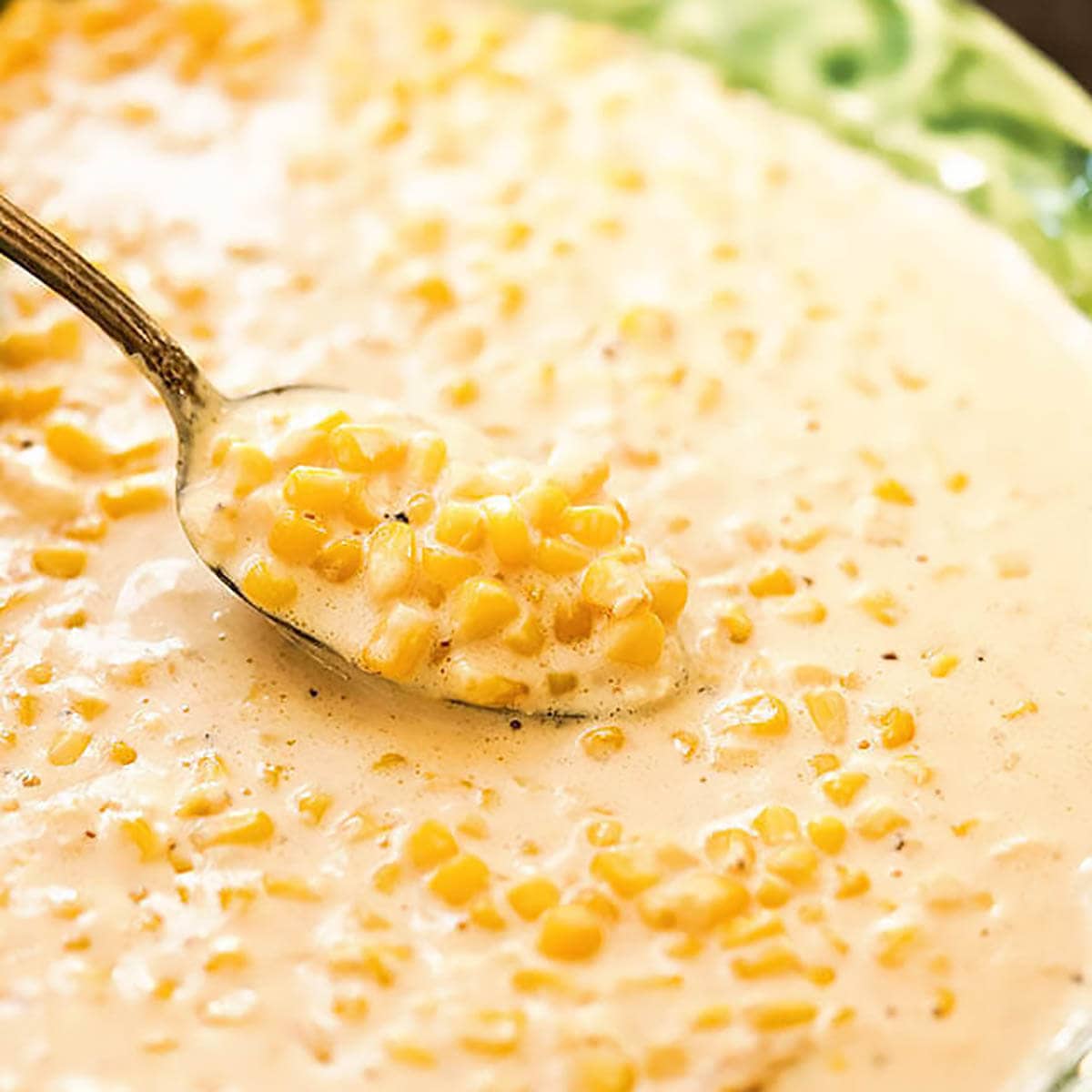 Creamed corn in serving bowl with spoon.