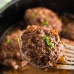 Salisbury steak in cast iron skillet with brown gravy. With Pinterest overlay.