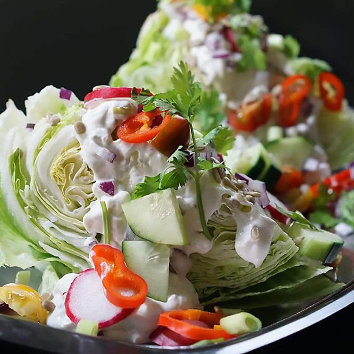 Outback wedge salad on large plate topped with blue cheese salad dressing.