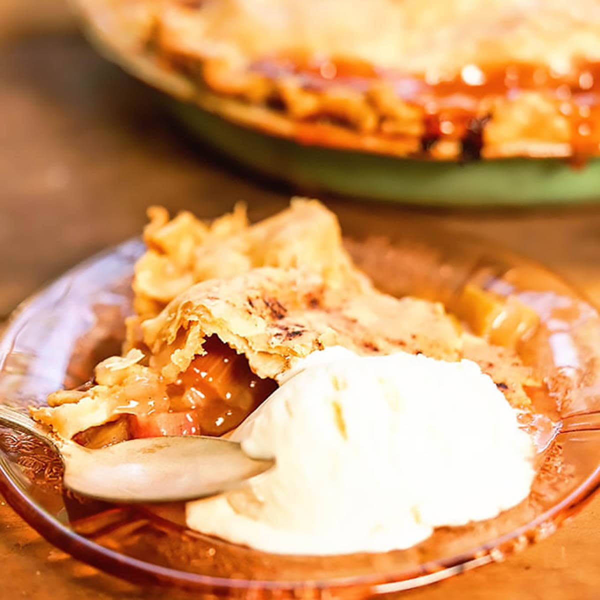 Rhubarb pie on plate with a scoop of vanilla ice cream.