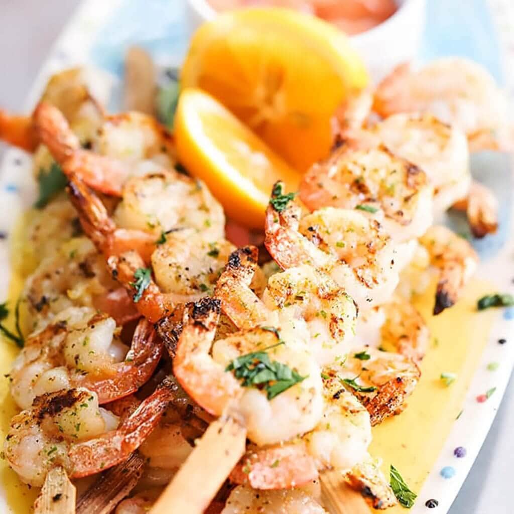 Grilled Shrimp Skewers on platter with lemon.