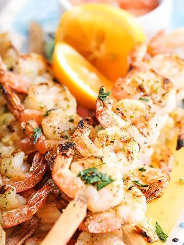 Grilled Shrimp Skewers on platter with lemon.