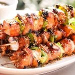 A platter filled with grilled teriyaki chicken kabobs sprinkled with sesame seeds for garnish.