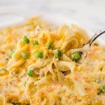 Noodle Casserole with peas on spoon.