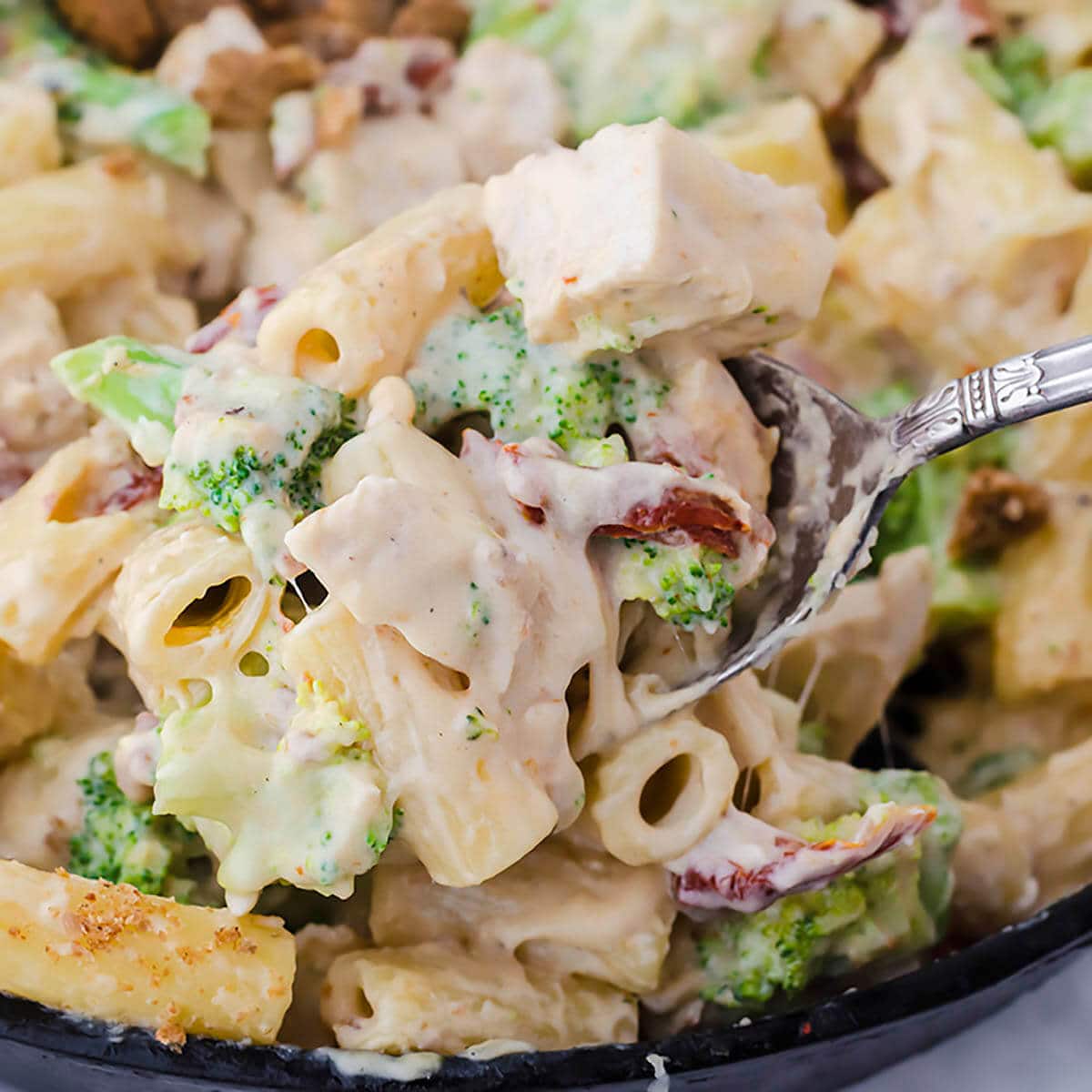 Pasta in skillet with serving spoon.