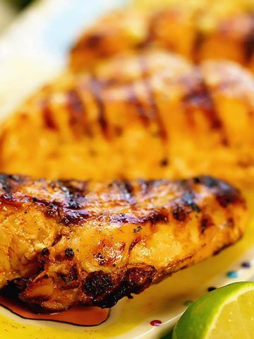 Grilled Chili Lime Chicken on platter served with a wedge of lime.