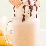 Banana Split Milkshake topped with whipped cream and fudge. With Pinterest overlay.