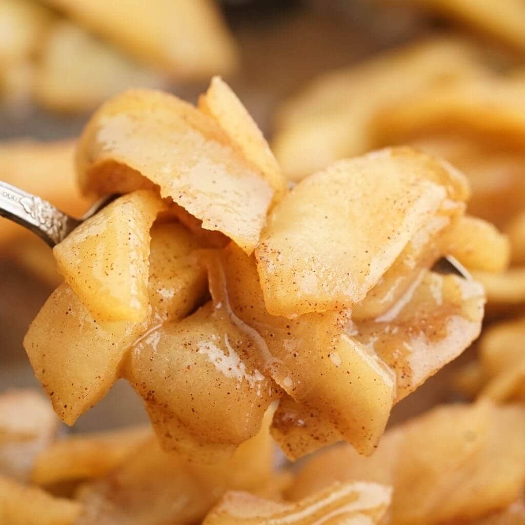 Fried apples on spoon. 