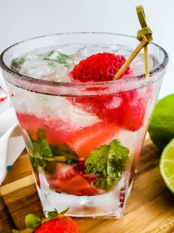Strawberry Mint Mojito with white rum garnished with lime and strawberry.