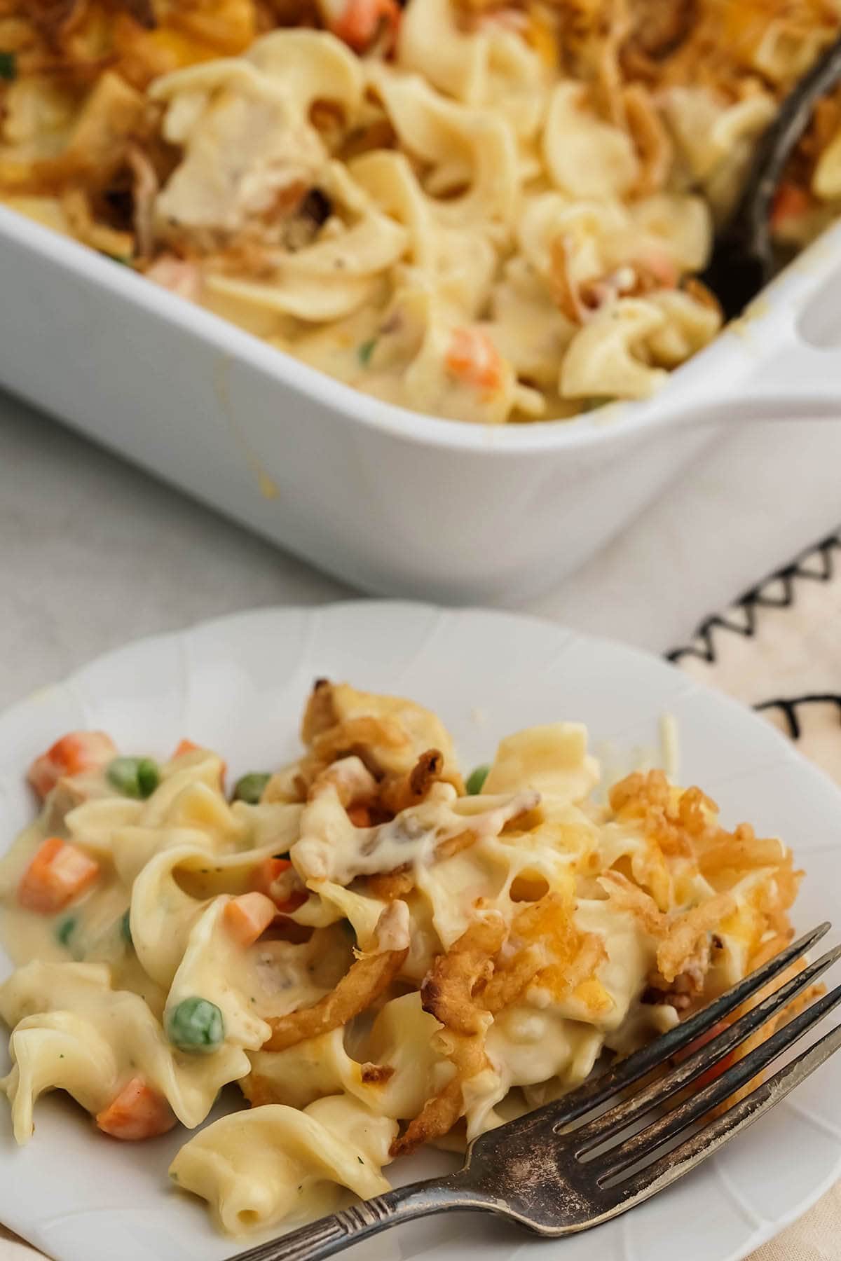 Chicken Noodle Casserole on plate with casserole in the background.