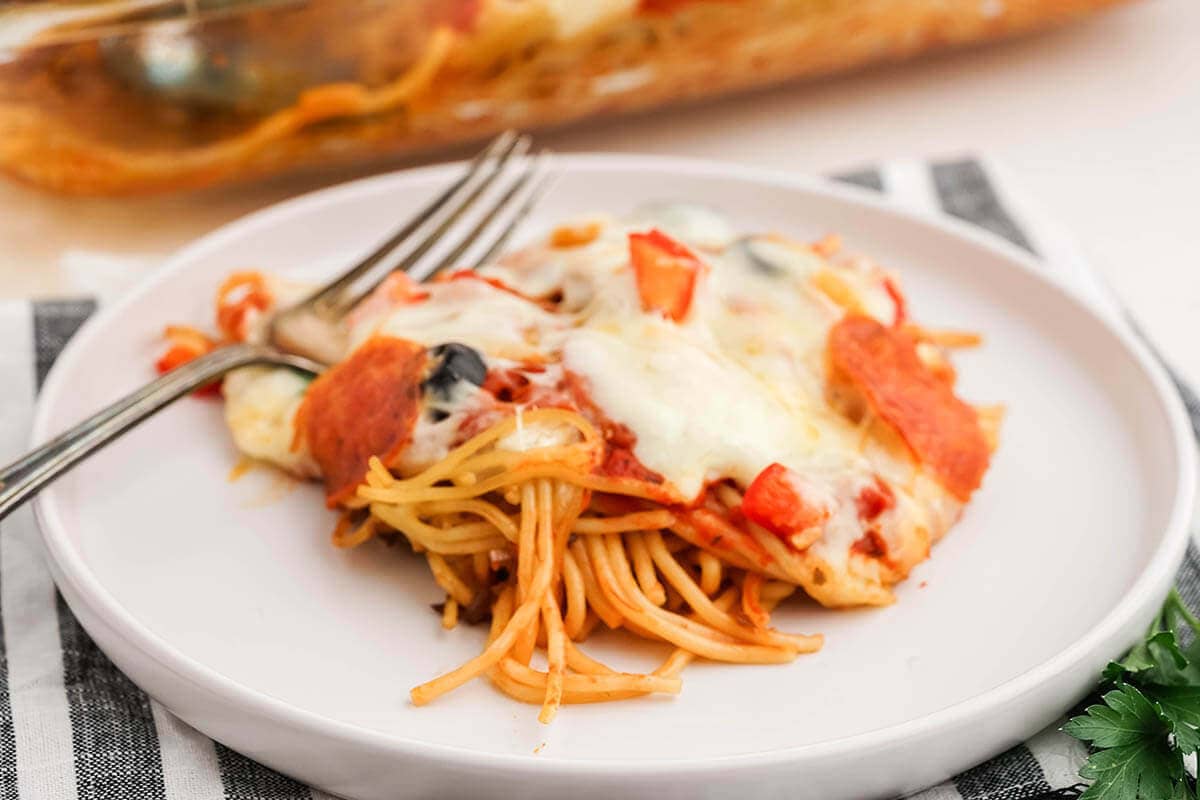 Cheesy Spaghetti Casserole on plate with fork.