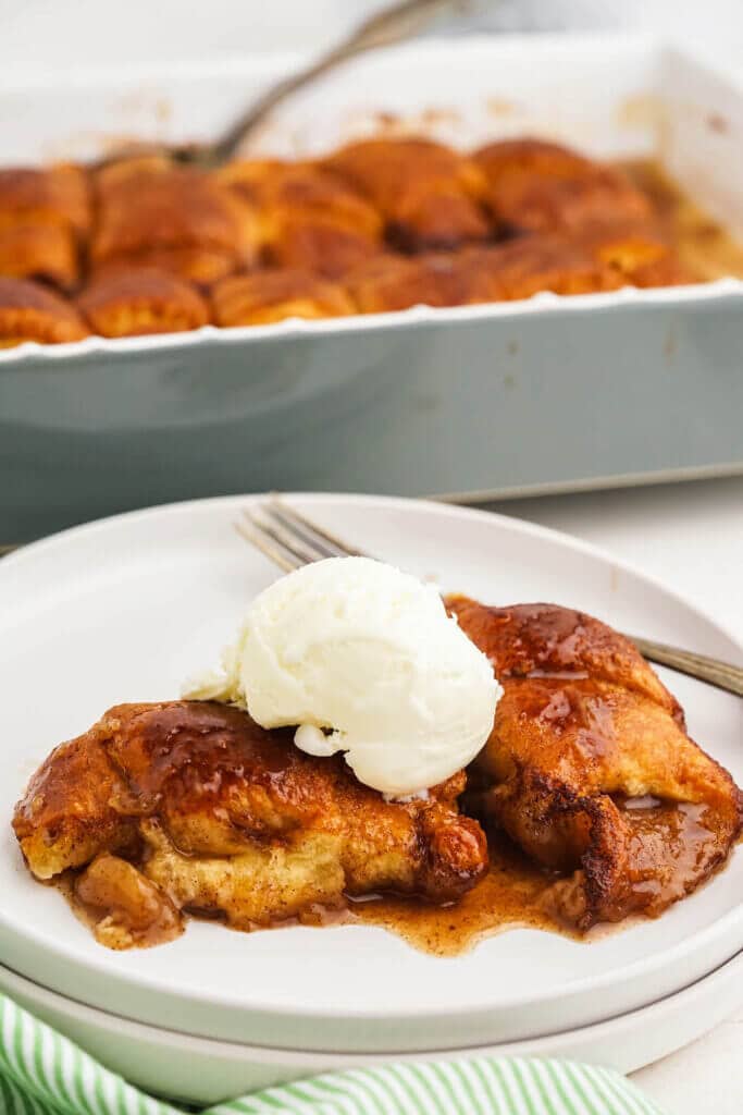 Mountain Dew Apple Dumplings on plate topped with vanilla ice cream.