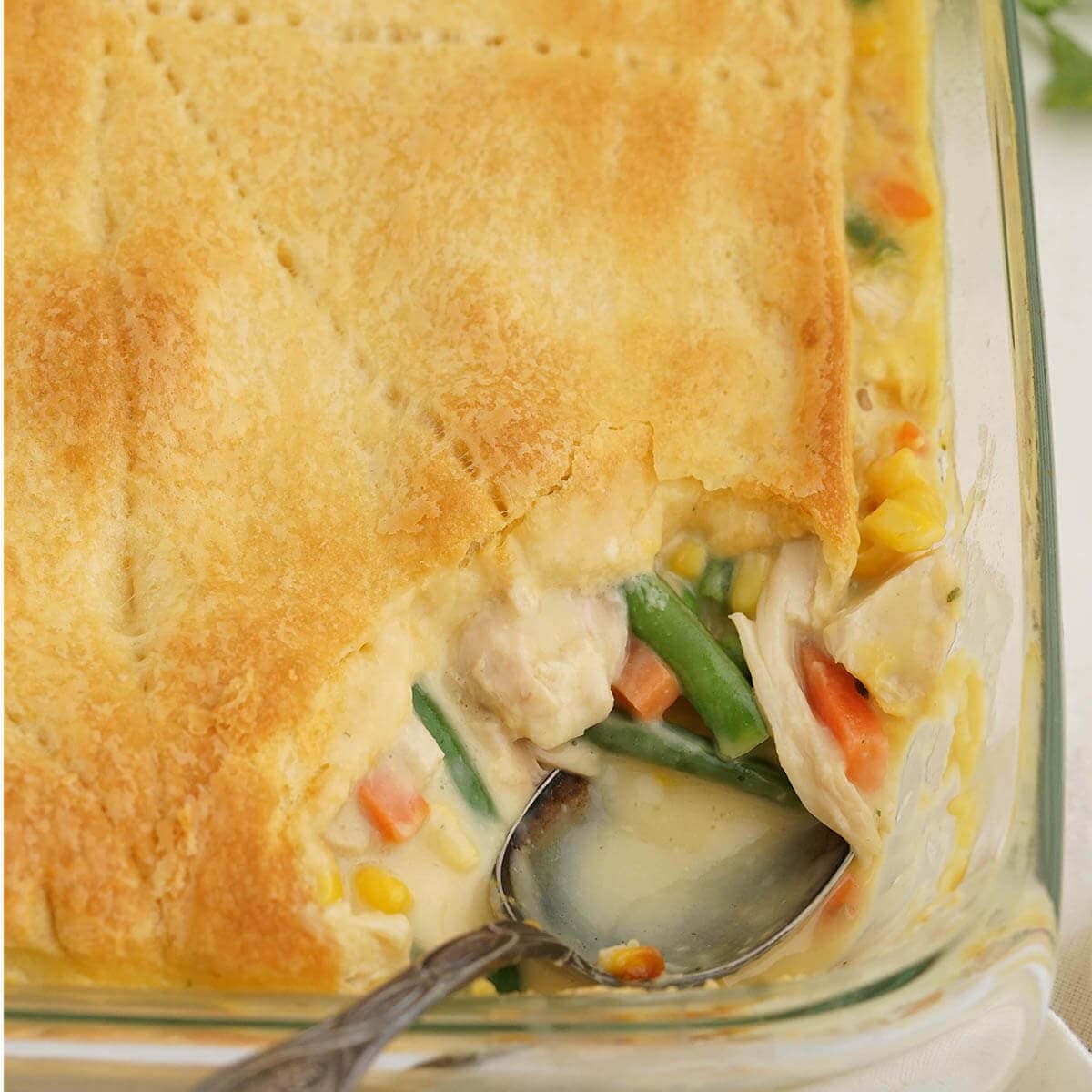 Chicken Pot Pie in Casserole dish with serving spoon.