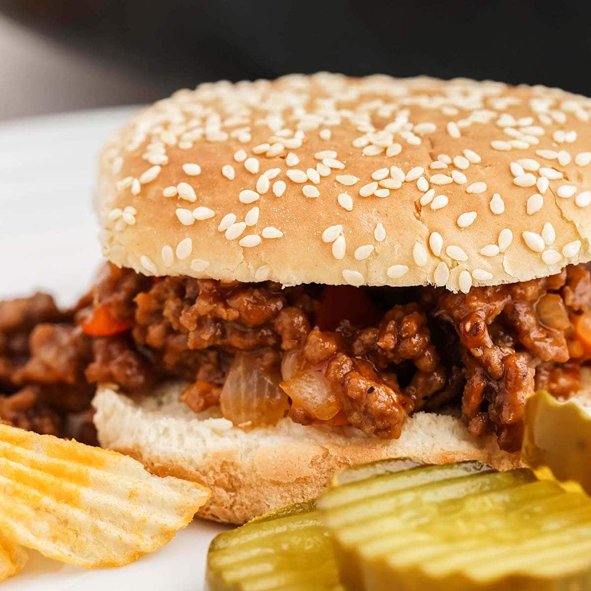 Homemade Manwich on bun with pickles and chips. 