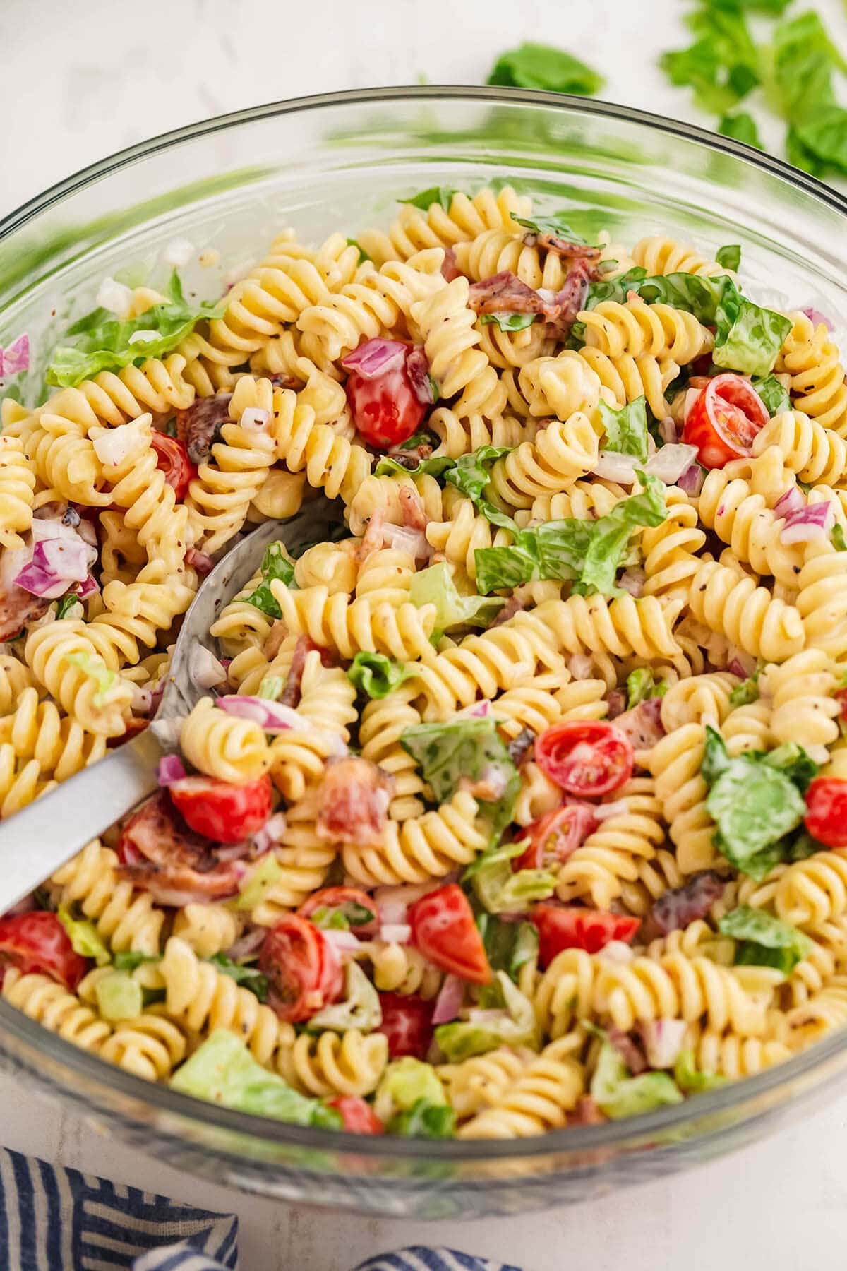 B L T Pasta Salad in bowl with serving spoon.