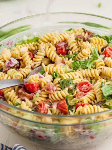 BLT Pasta Salad in large bowl with serving spoon.