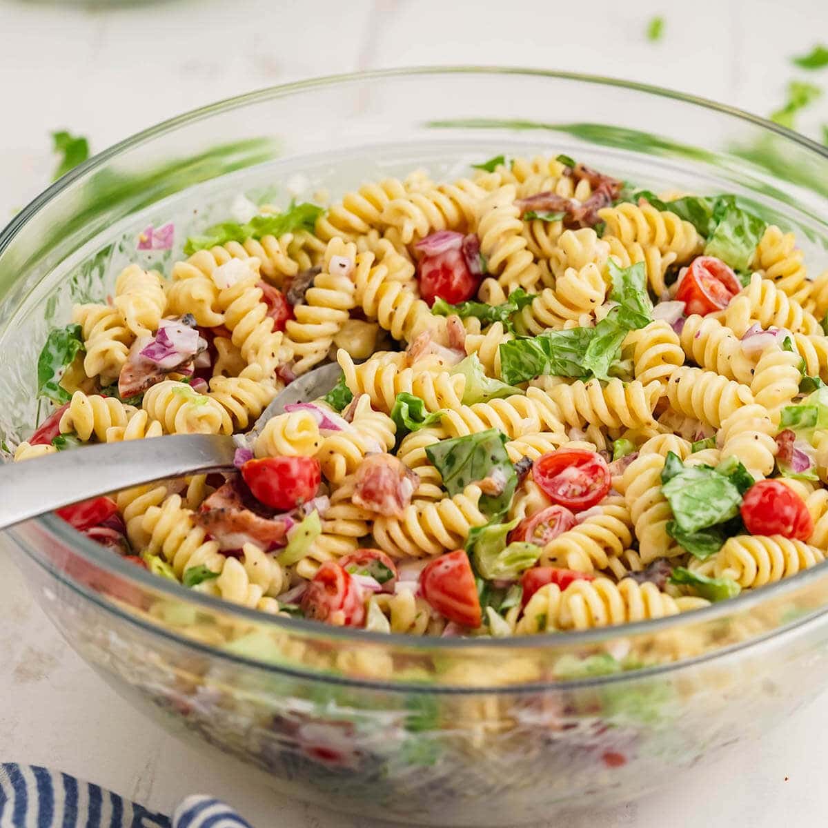 BLT Pasta salad in bowl with spoon. 