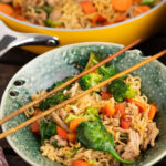 Pan-fried noodle dish in bowl with chopsticks.