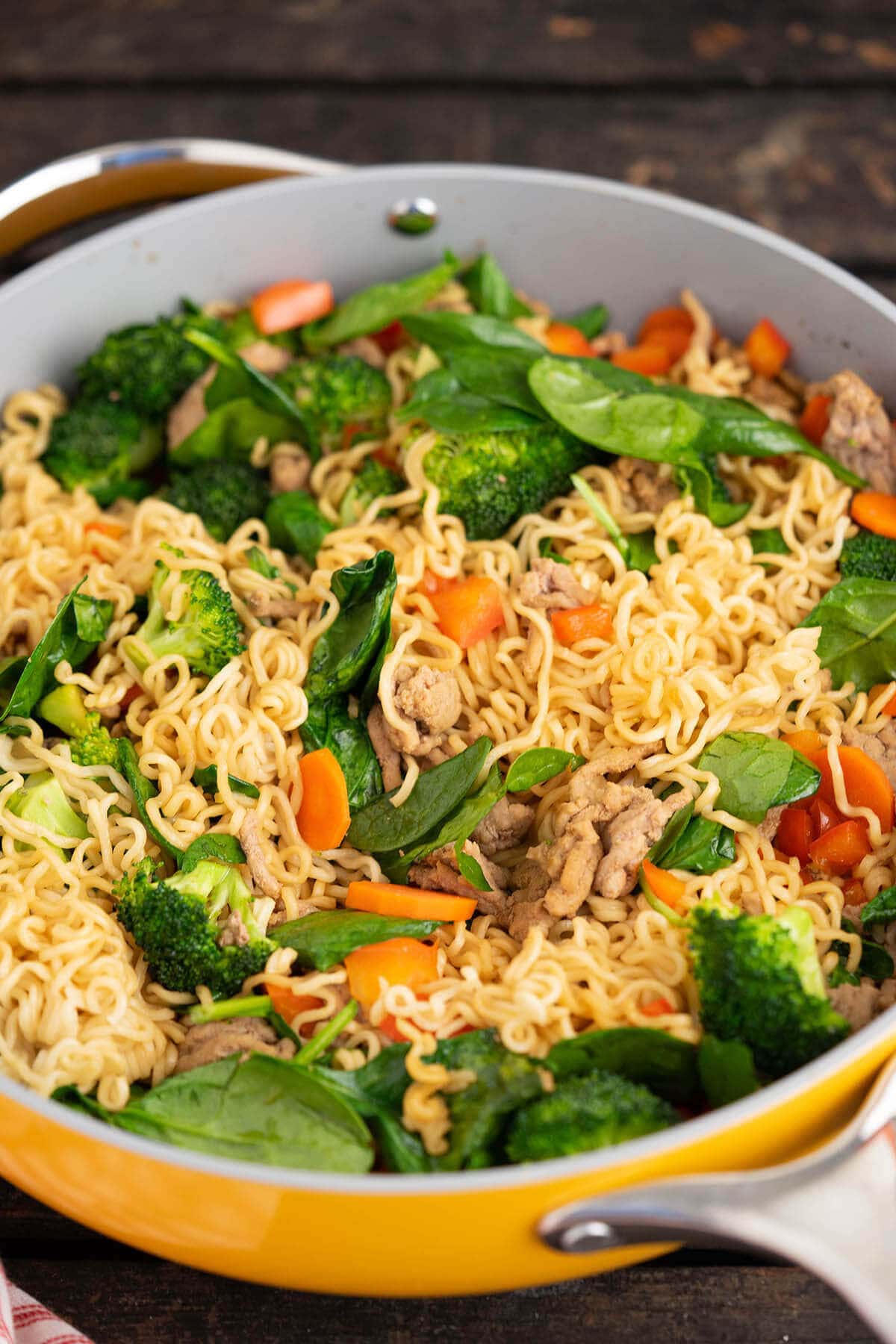 Pan fried ramen noodles with teriyaki sauce and vegetables in skillet. 