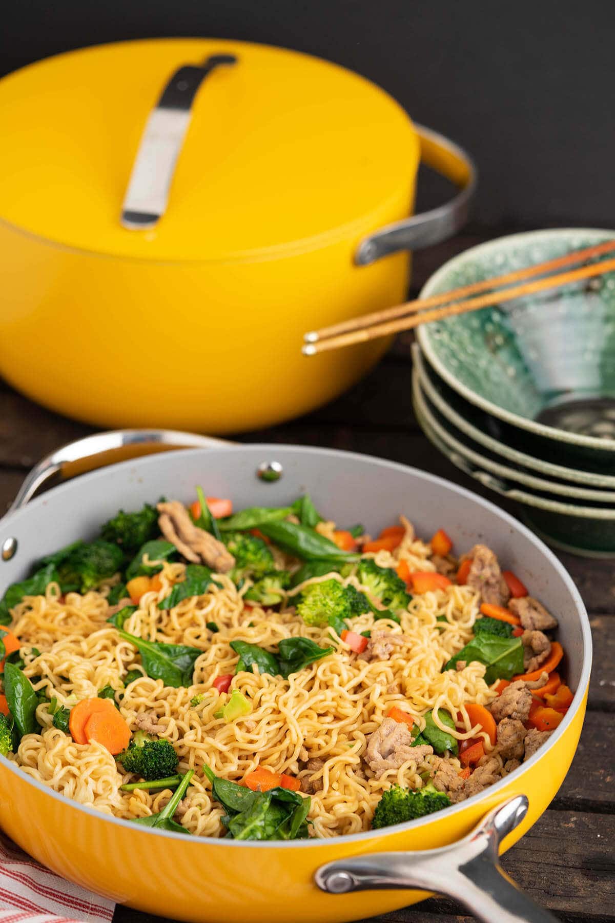 Teriyaki Ramen Noodles in fry pan with serving bowls and Dutch oven.