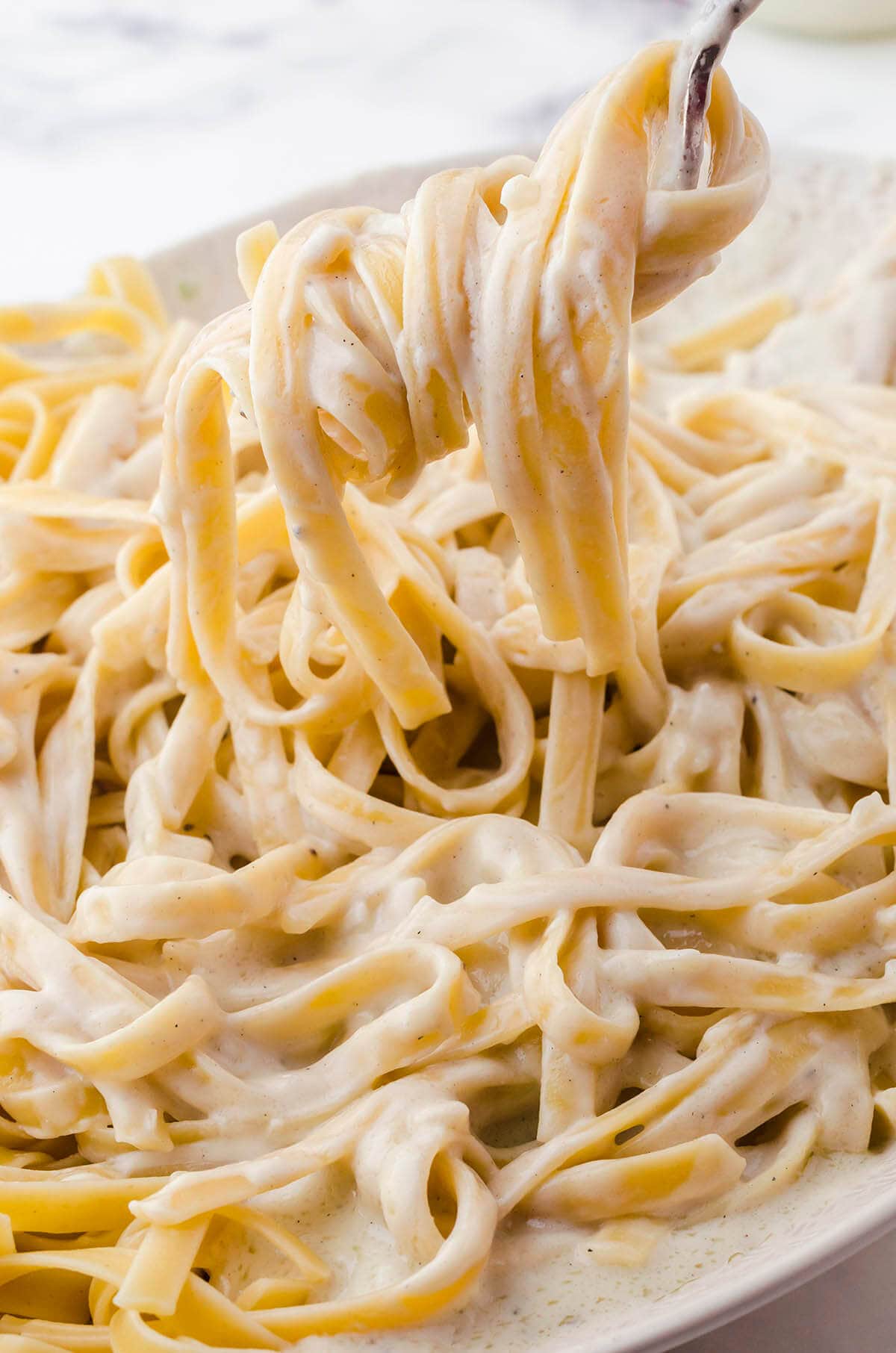 Fettuccini pasta topped with Better Than Olive Garden Alfredo Sauce.