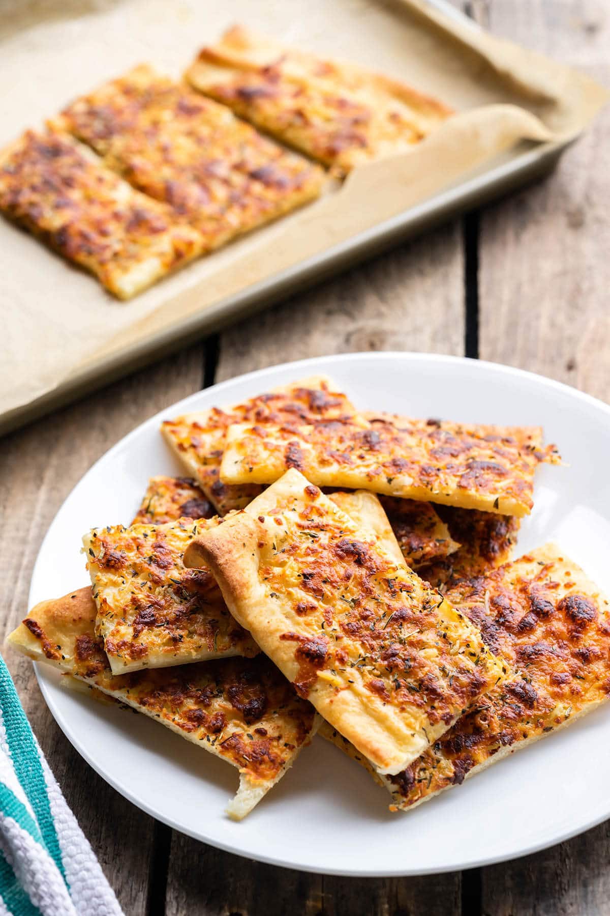 Breadsticks on plate with more on sheet pan.