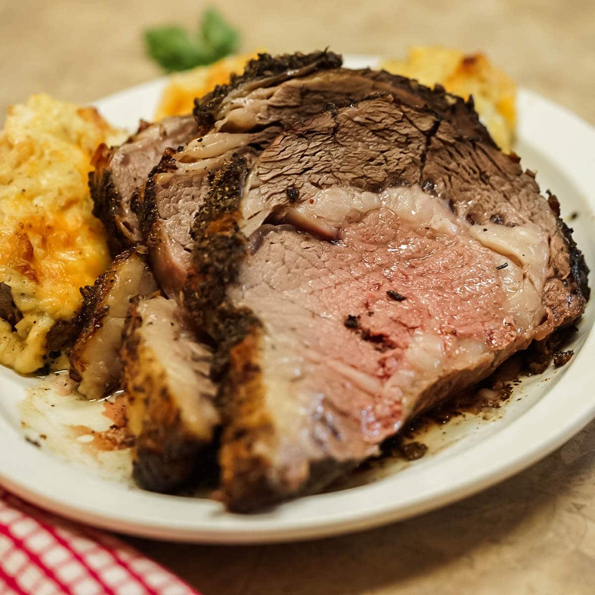 Sliced Prime Rib on platter with baked potatoes. 