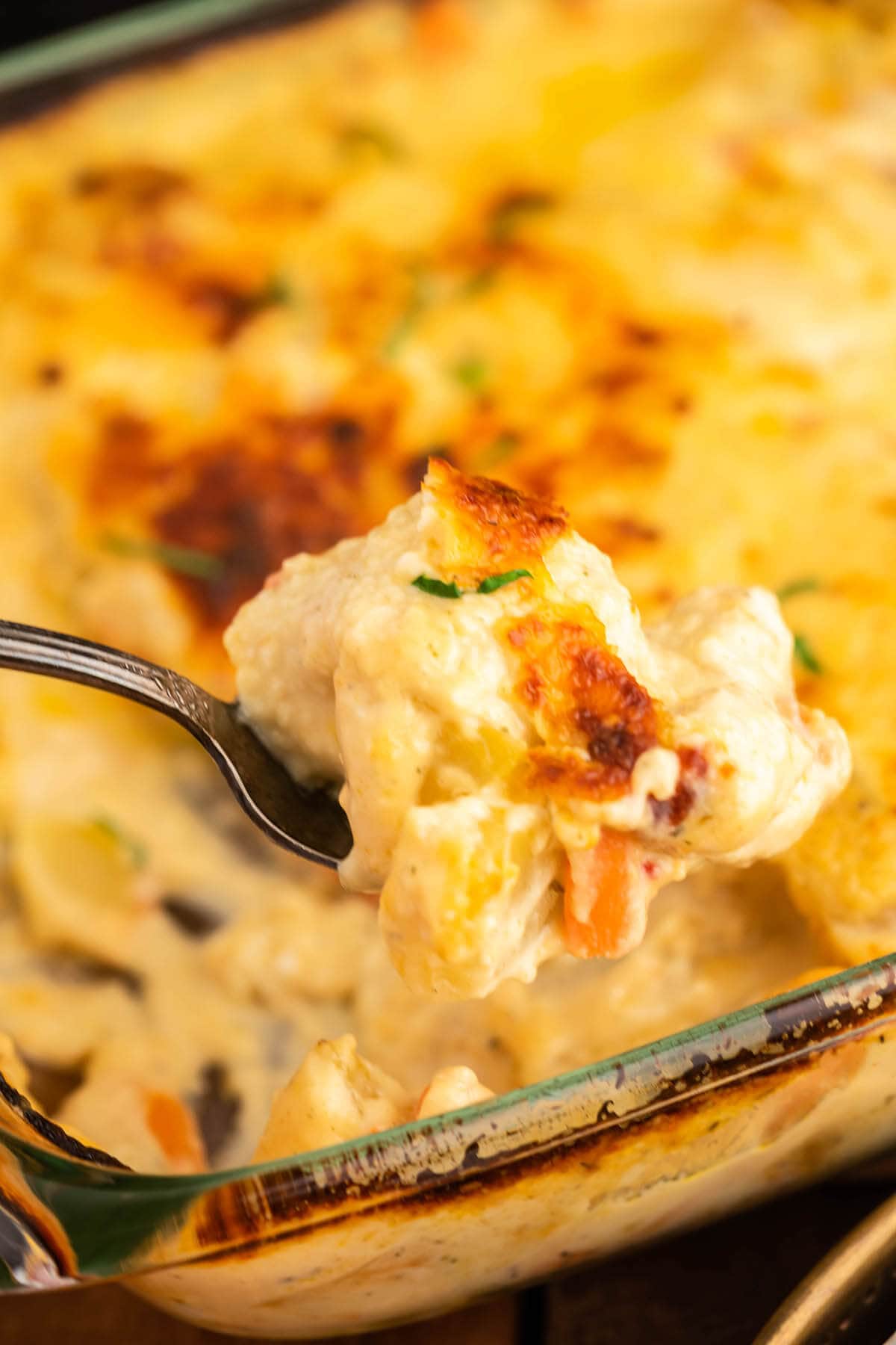 Creamy Chicken and Potato Bake in casserole dish with serving spoon.