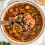 Dutch oven filled with rich Guinness Beef Stew with ladle taking a big scoop.