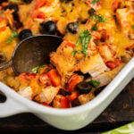 Chicken Enchilada Casserole in baking dish with serving spoon.