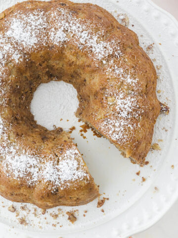 Overhead photo of apple spice bundt cake on plate sprinkled with powdered sugar.