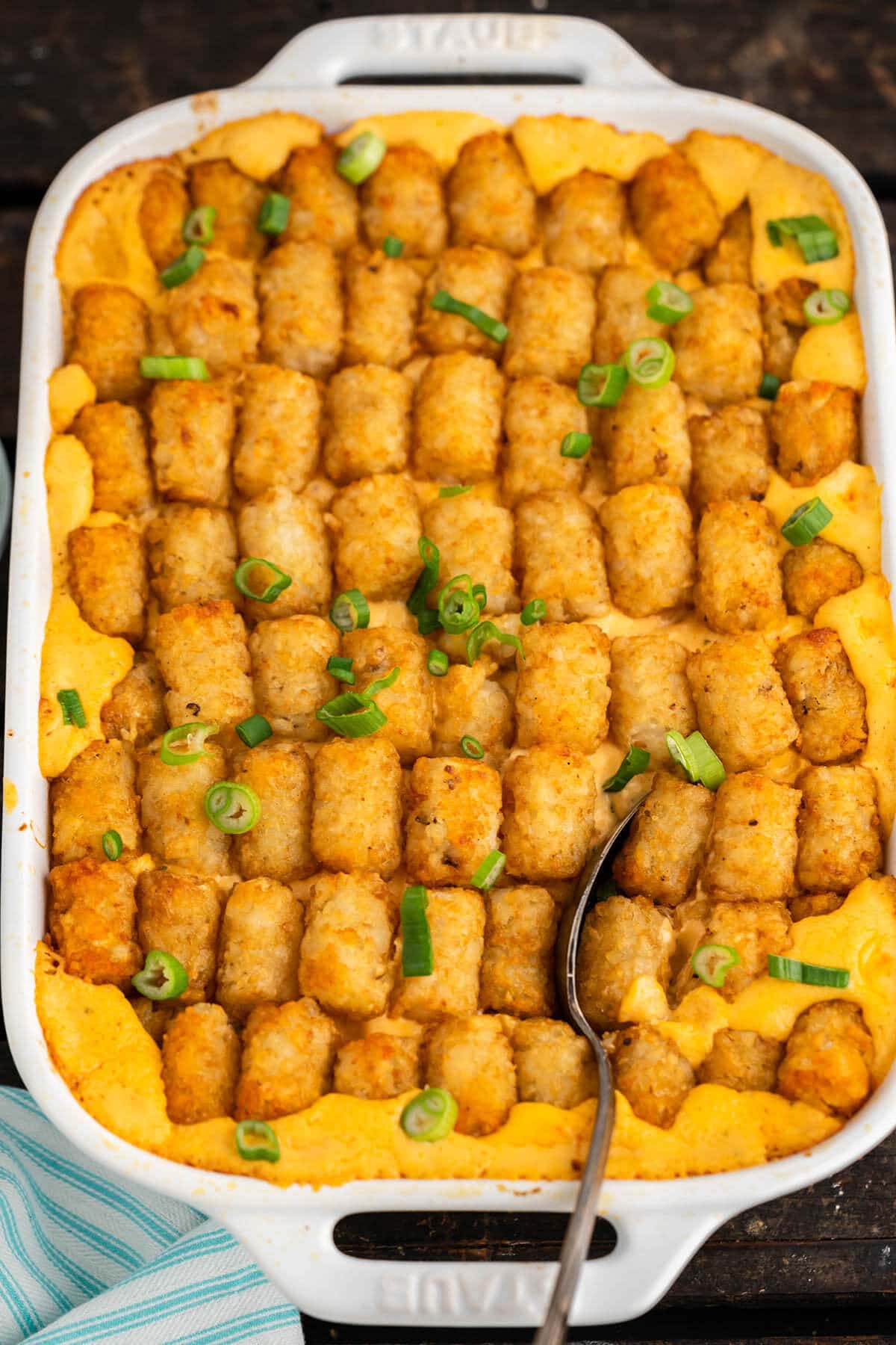 Buffalo Chicken Tater Tot Casserole in baking dish with serving spoon. 